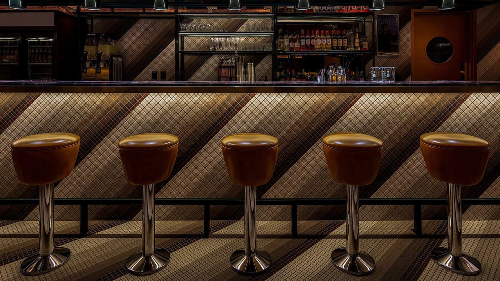 Photo of the bar, showing the brown vintage barstools and diagonal tile pattern