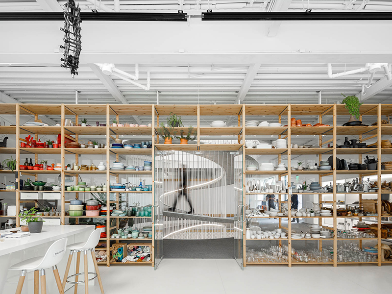 View of spiral staircase behind the open shelving in the kitchen