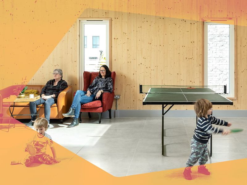 Women sitting in lounge chairs while children play in front