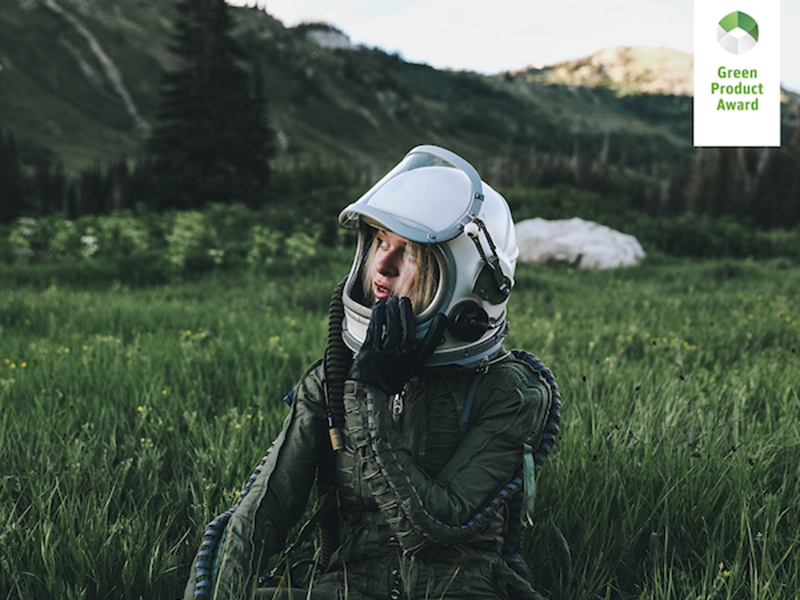 Woman in astronaut helmet in a field. Text reads: Green Product Award.