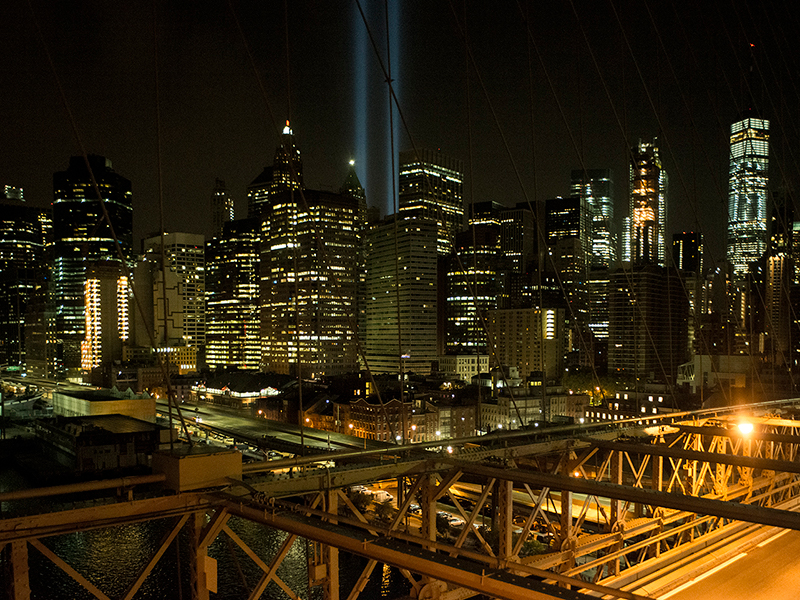 View west from the Brooklyn Bridge capturing the annual September 11 “Tribute in Light,” a commemorative art installation that recreates the shapes of the towers, Brooklyn, New York; 2017.