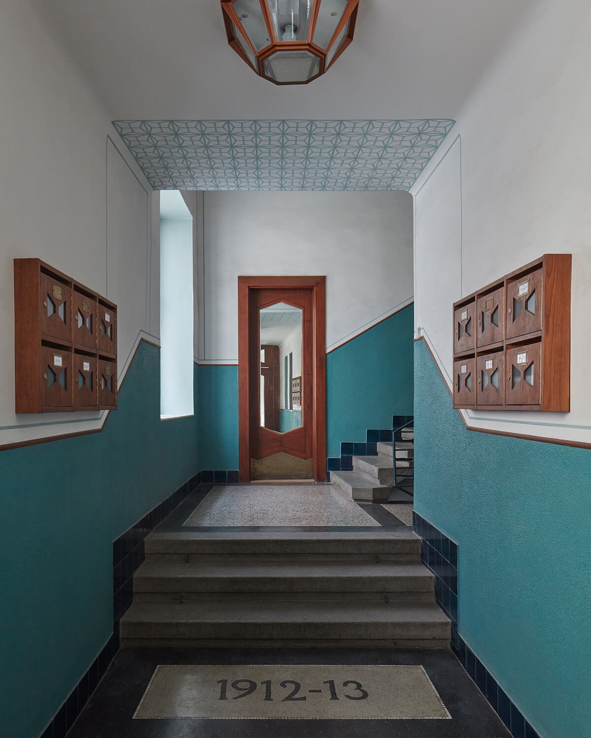 Staircase up to BOMMA Atelier showing teal accent walls