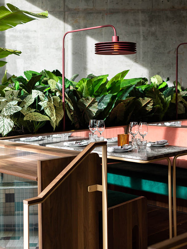 Banquette with greenery and red lamp