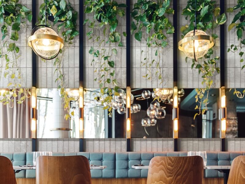 Crogliolo Lume white wall tiles in restaurant with plants and chairs