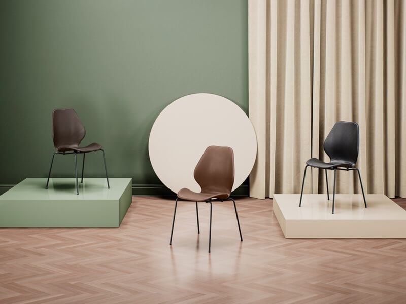 Material Matters Exhibiton featuring brown and black leather seats in front of green and beige background