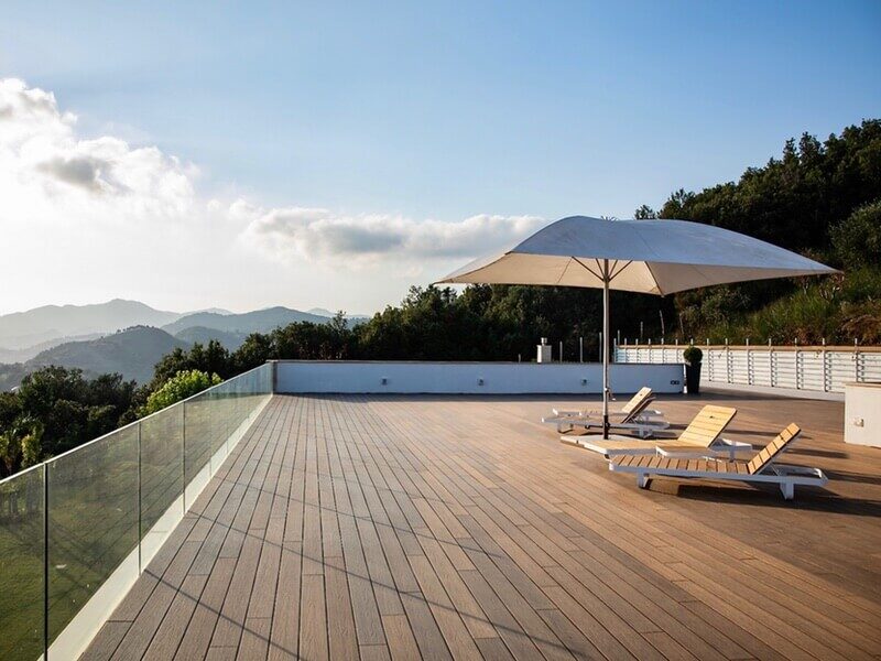 Newtechwood Decking Solutions outdoor wood composite deck flooring on rooftop pooldeck bedise valley with outdoor sun umbrella and lawnchairs