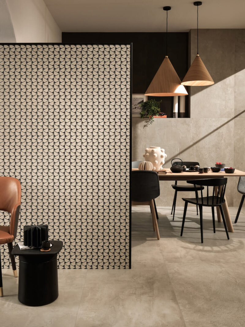 Dining room setting with a tile wall, accented by bold black Ciot grout.