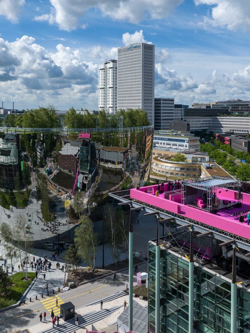 A forested rooftop park design by MVRDV built on top of a mirrored art storage facility.