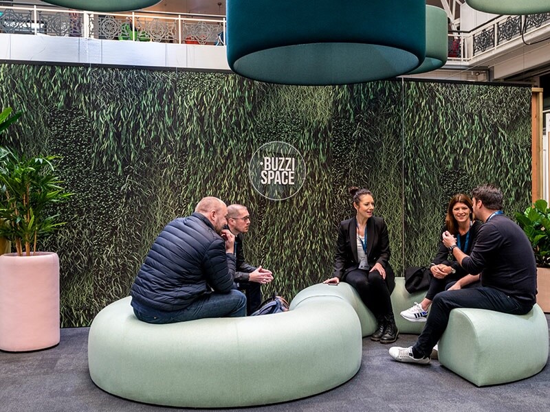 Workspace Design Show 2023 men and women sitting on bean bag chairs during exhibition