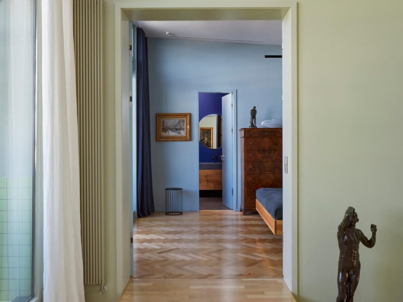 A view from the living room of the apartment into the bedroom and bathroom, showing the colour-block Coordination design.