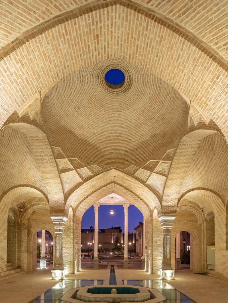 View inside a restored inner courtyard, showing brick arches and columns