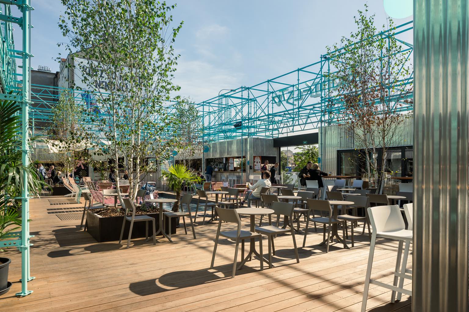 Manifesto Market in Prague's Andel district, designed by Chybik + Kristof with a central dining area bordered by corrugated aluminum food stalls.