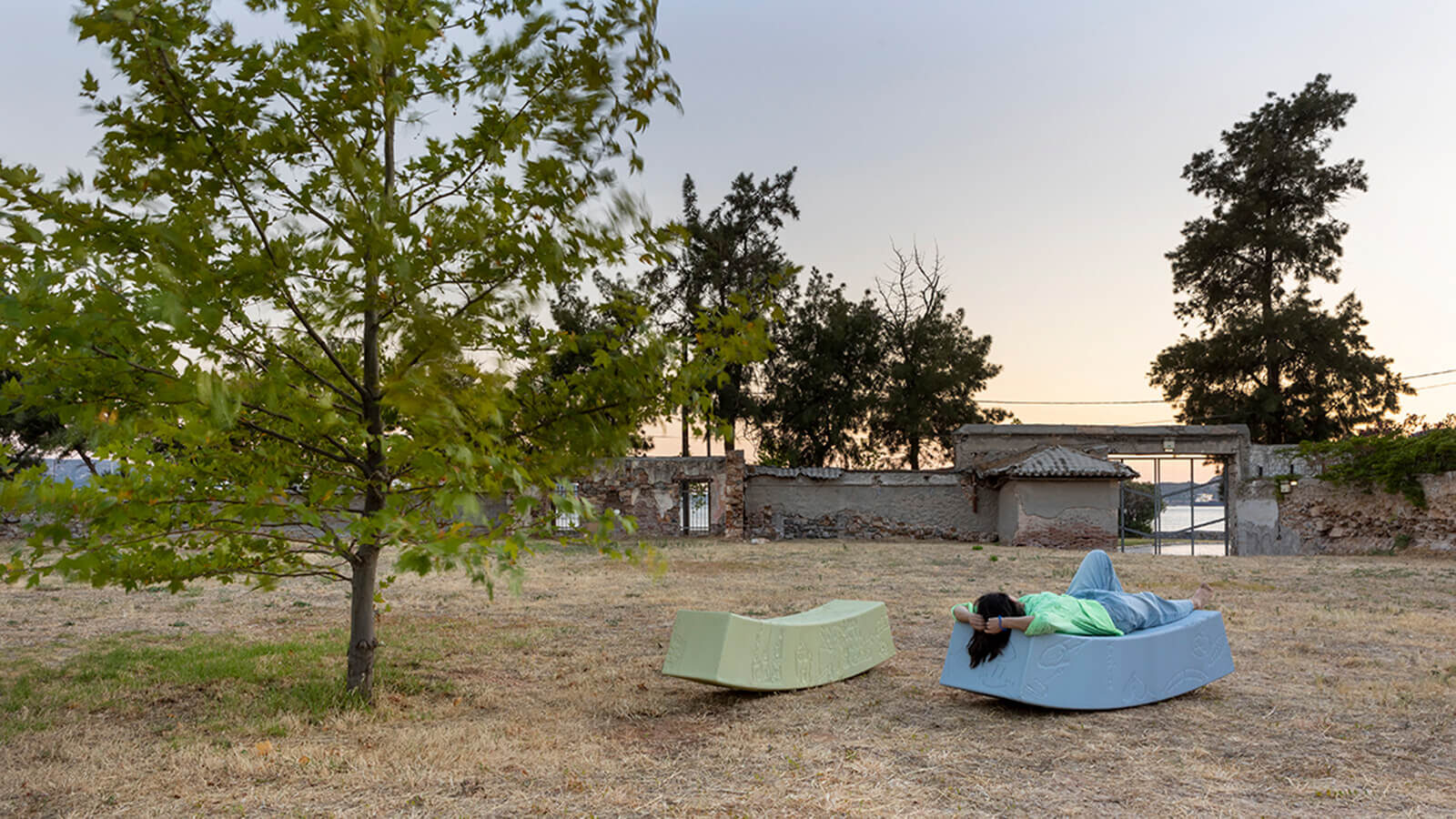 Person lying on blue bench