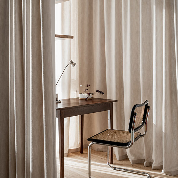 Office with flax-coloured curtain, antique desk and chair