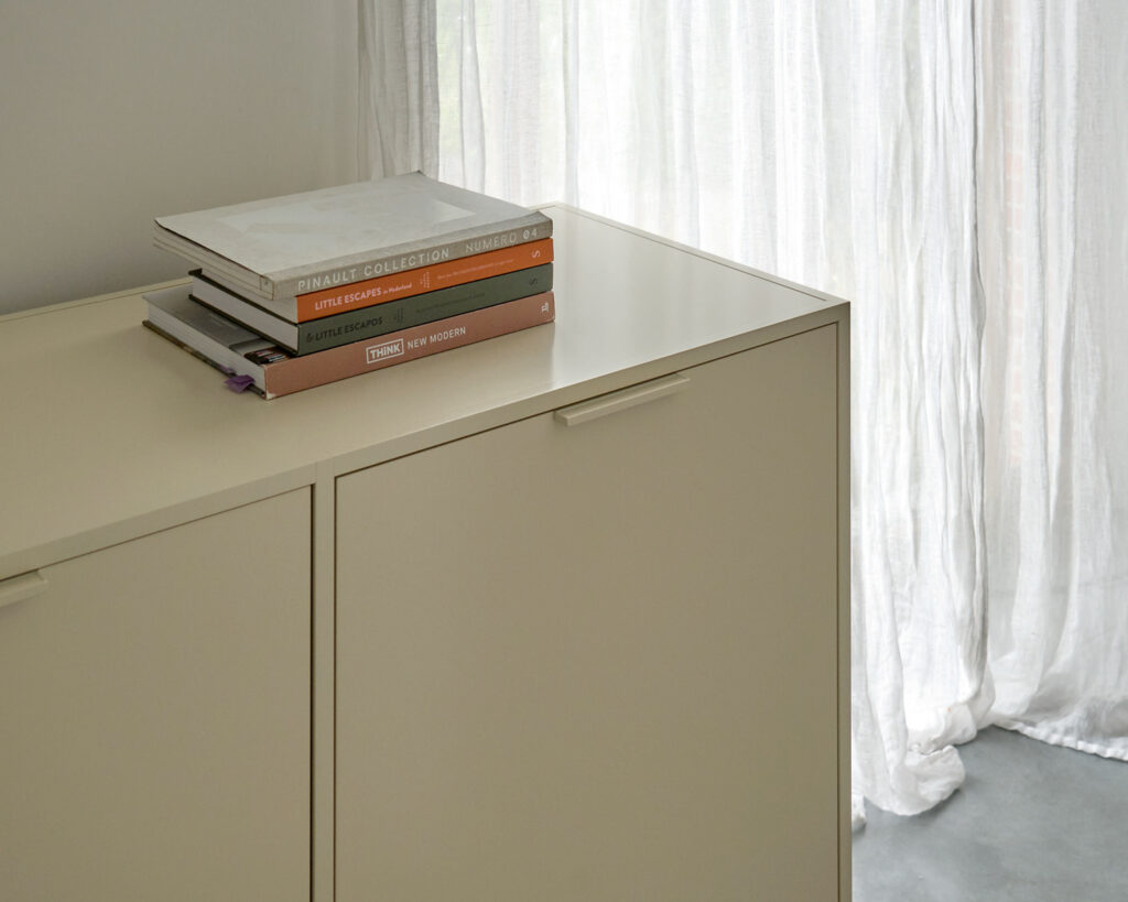 Close up of beige cabinet with stack of books on top