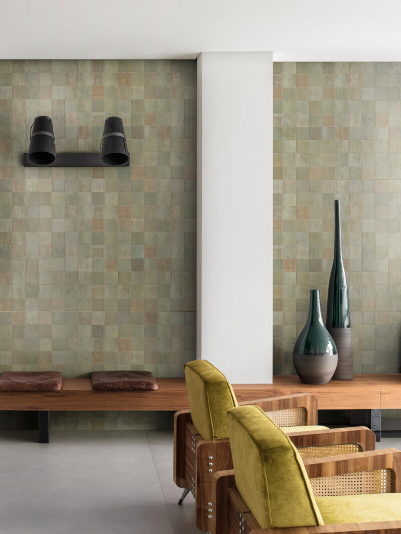 Zellige wall tiles in a range of green hues, shown in a living room setting.