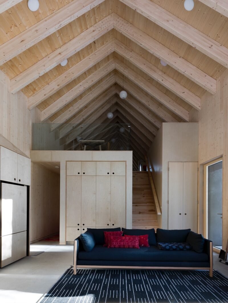 A view towards the stairs and upstairs loft in a pending Passive House in Ontario that features glulam rafters that grow gradually steeper.
