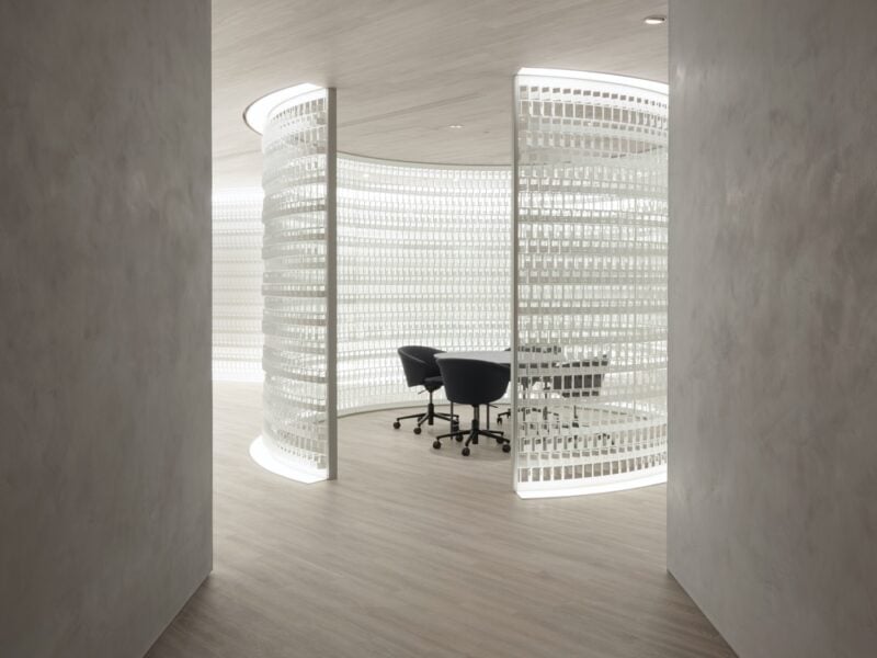 Curved sheets with punch outs inspired by Pokémon cards wrap around a meeting room setup in the Tokyo office of Creatures Inc., designed by Nendo.