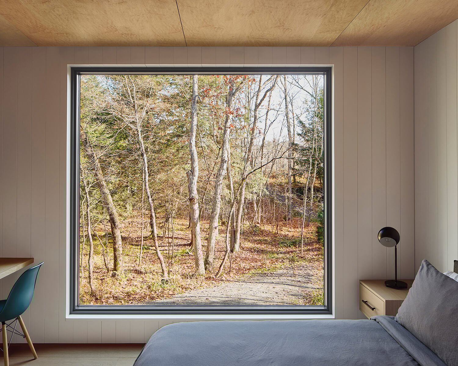 Large geometric windows are positioned to capture perfectly framed views to the outside. Minimalist furnishings provide comfort and moments of colour without imposing on the design.