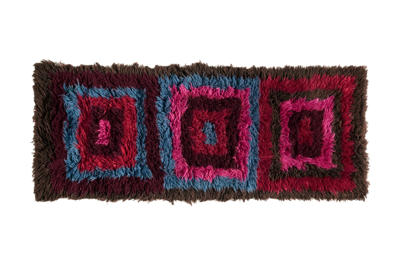 One of the best 2023 rug designs is Siroua by Beni Rugs, a long rectangular rug featuring concentric squares in pink and maroon tones.