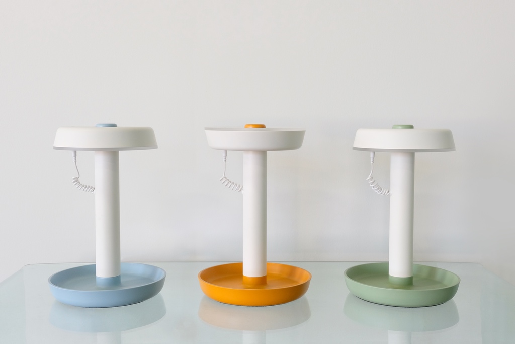 A trio of white table lamps with dish-shaped bases and round circular shades that are attached with phone cord-like wiring. The designer behind them is the Toronto design studio Castor.