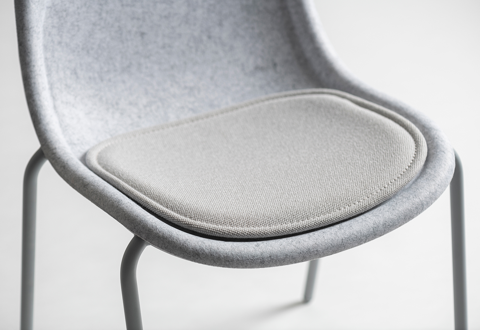 Close up of grey felt chair with seat pad