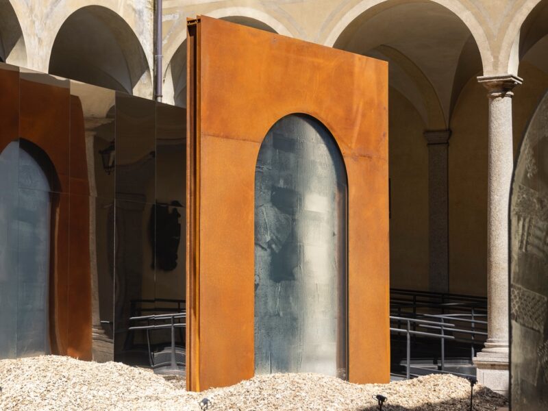 For Milan Design Week 2024, Lasvit presented a series of glass doorways framed in corten steel in a courtyard of a historic palazzo.