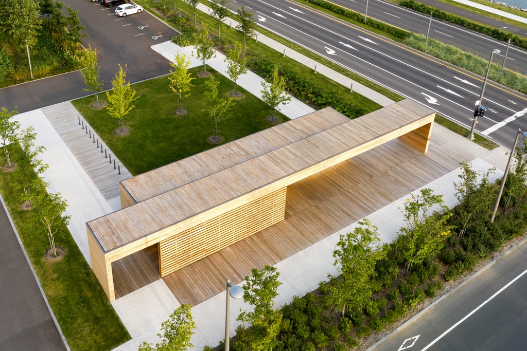 Ann aerial view of an open-air wood beach pavilion at Promenade Samuel-de Champlain in Quebec City. It's surrounded by landscaped gardens with trees and shrubs.