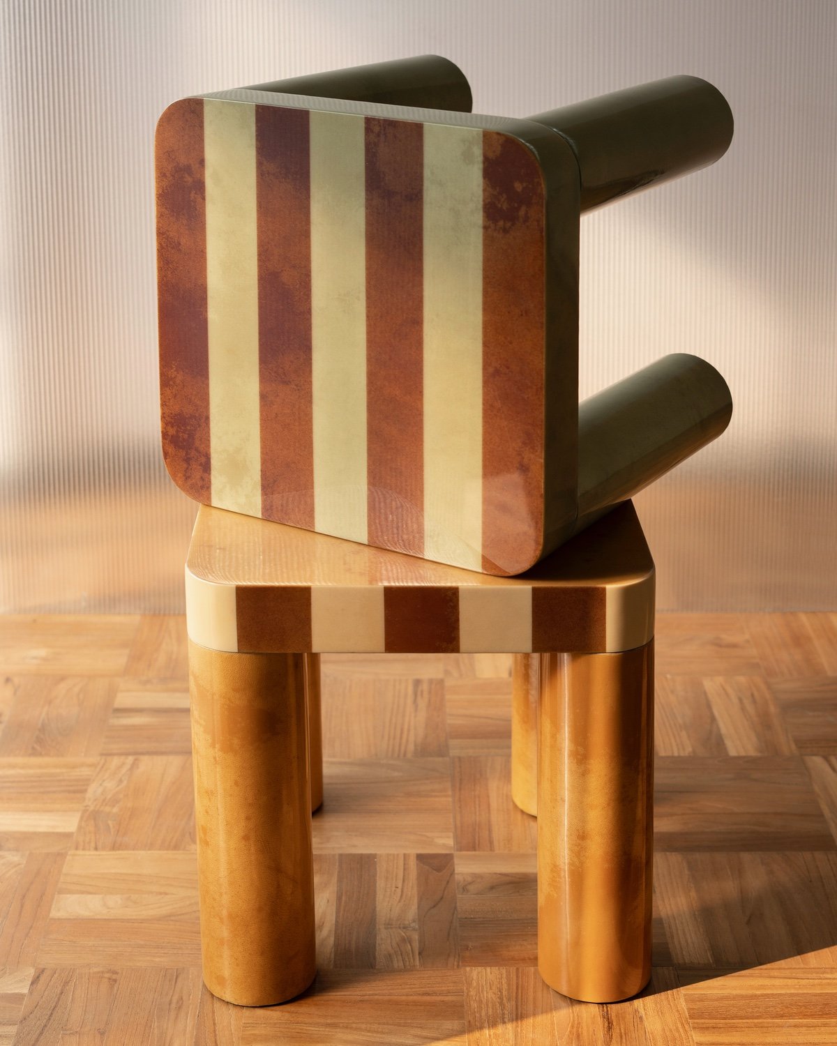 Two side tables stacked on top of each other. Each one features a striped glossy top and a mottled texture on the legs.
