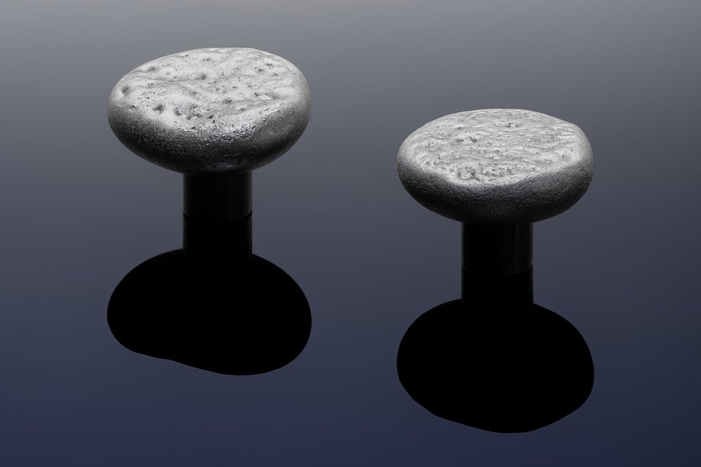 A pair of door knobs that look like moon craters, shown against a navy background.
