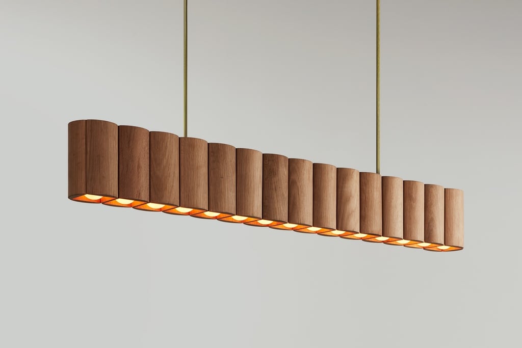A modern cottagecore chandelier made up of a row of wooden tubes.