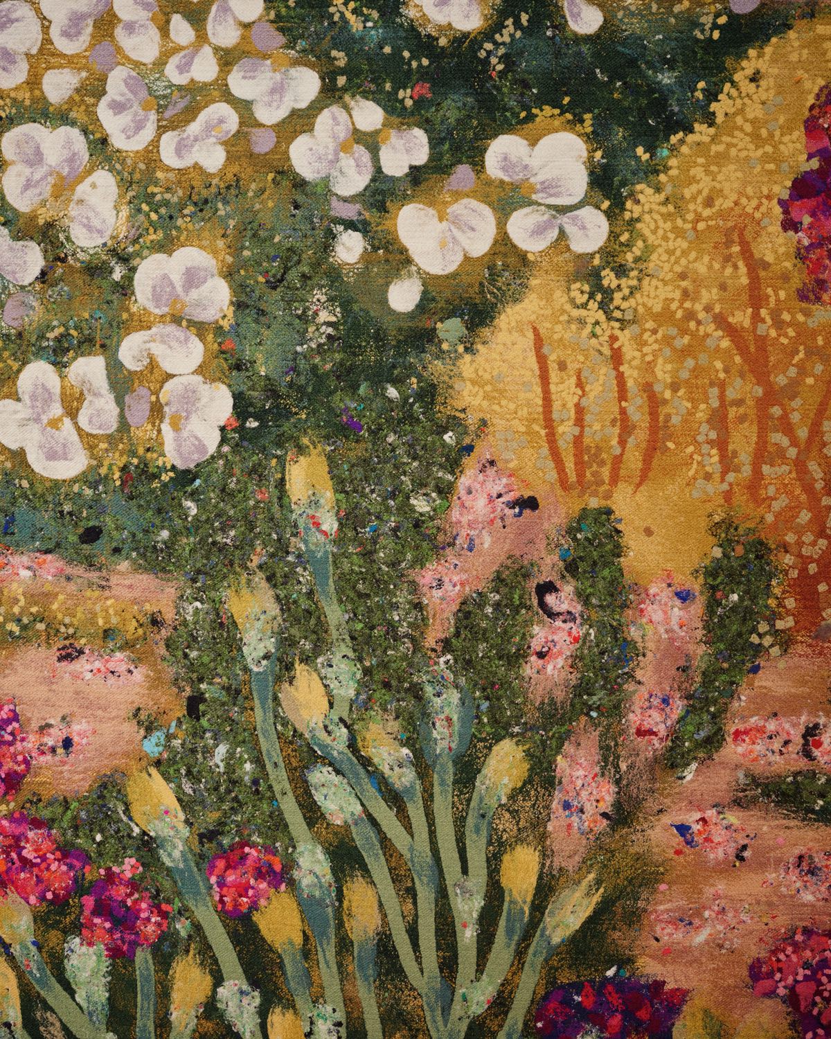 A closeup of a modern cottagecore textile wall covering design showing a rural field filled with white, yellow and pink flowers.