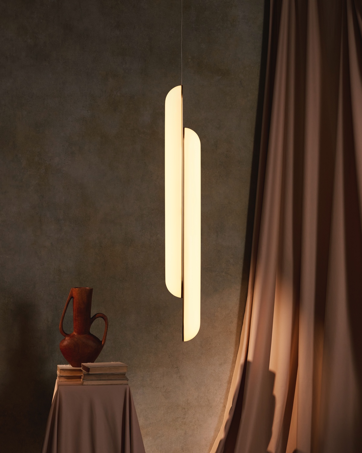 A Gemini pendant from the Alchemist lighting collection by Lee Broom featuring two vertical glowing tubes.