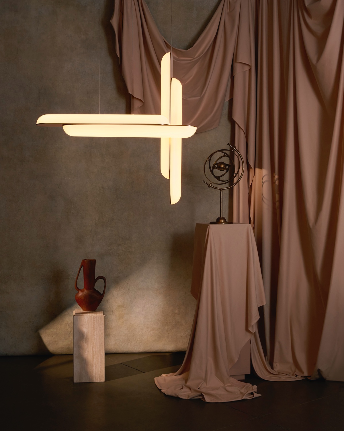 A Gemini pendant from the Alchemist lighting collection by Lee Broom featuring two vertical and two horizontal glowing tubes that cross-cross in an L shape.