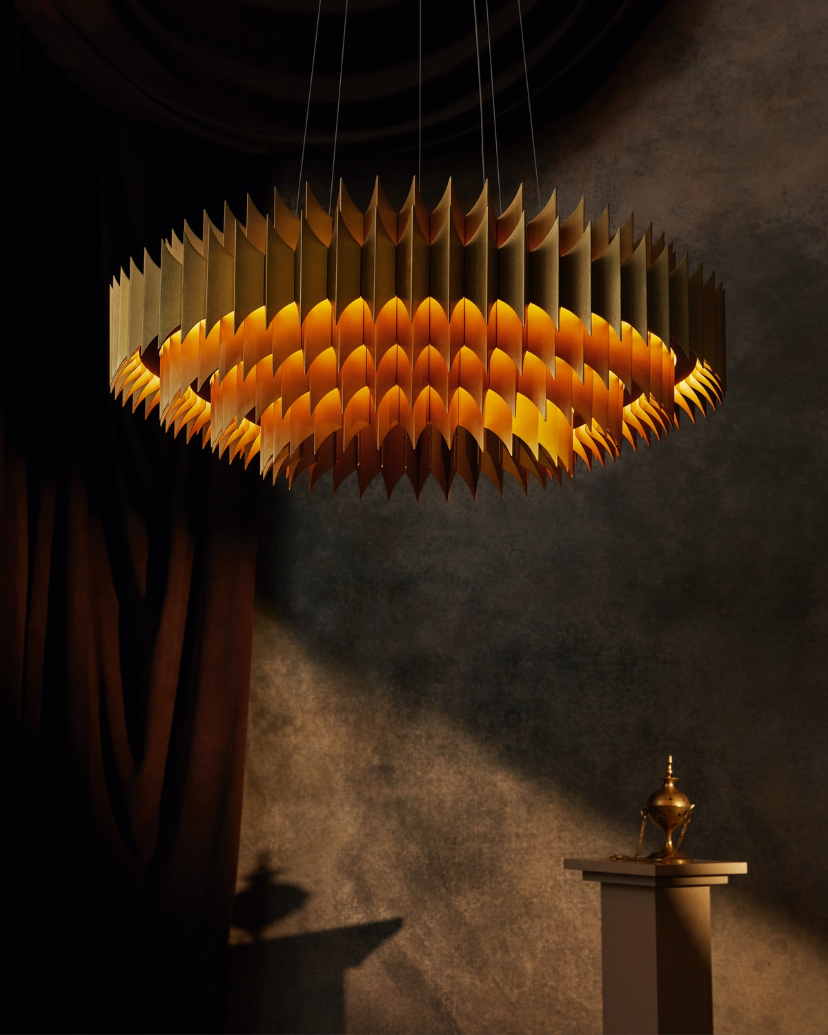 The King chandelier from the Alchemist collection by Lee Broom features several rings of small aluminum leaves that have been joined together. It glows from within.