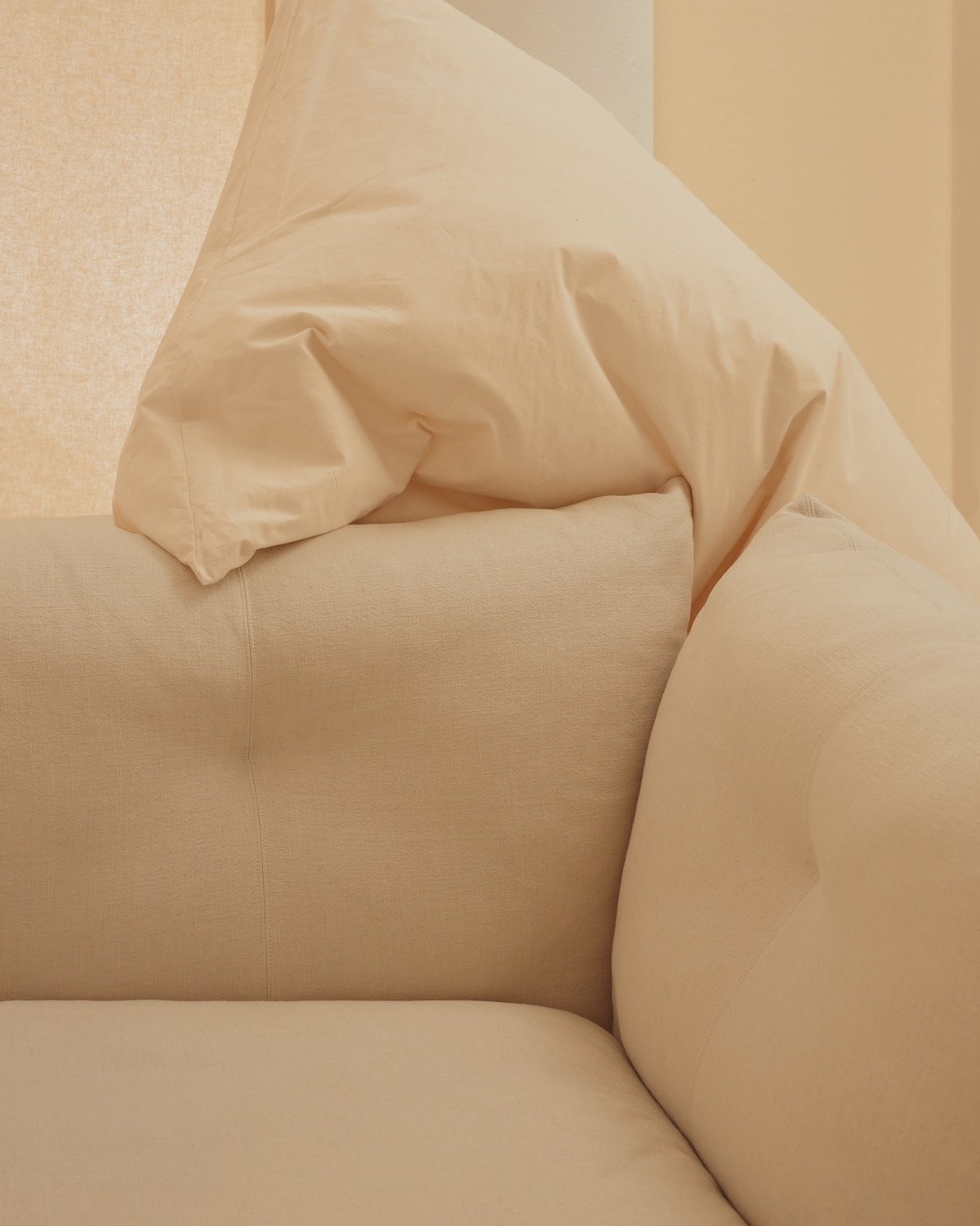 A pillow is folded over one of the cushions on Knoll's Pillo sofa.