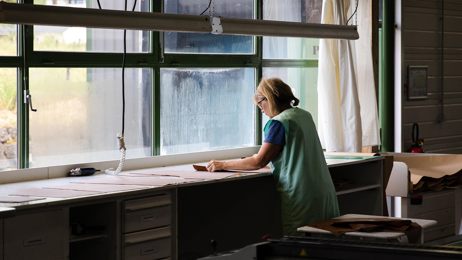 Woman stands by the window at Ligne Roset factory