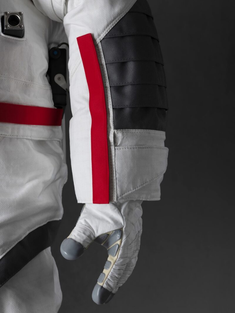 A view of a red stripe and webbed grey area along the arm of the spacesuit that Axiom Space and Prada designed for astronauts to wear on the next lunar landing mission.