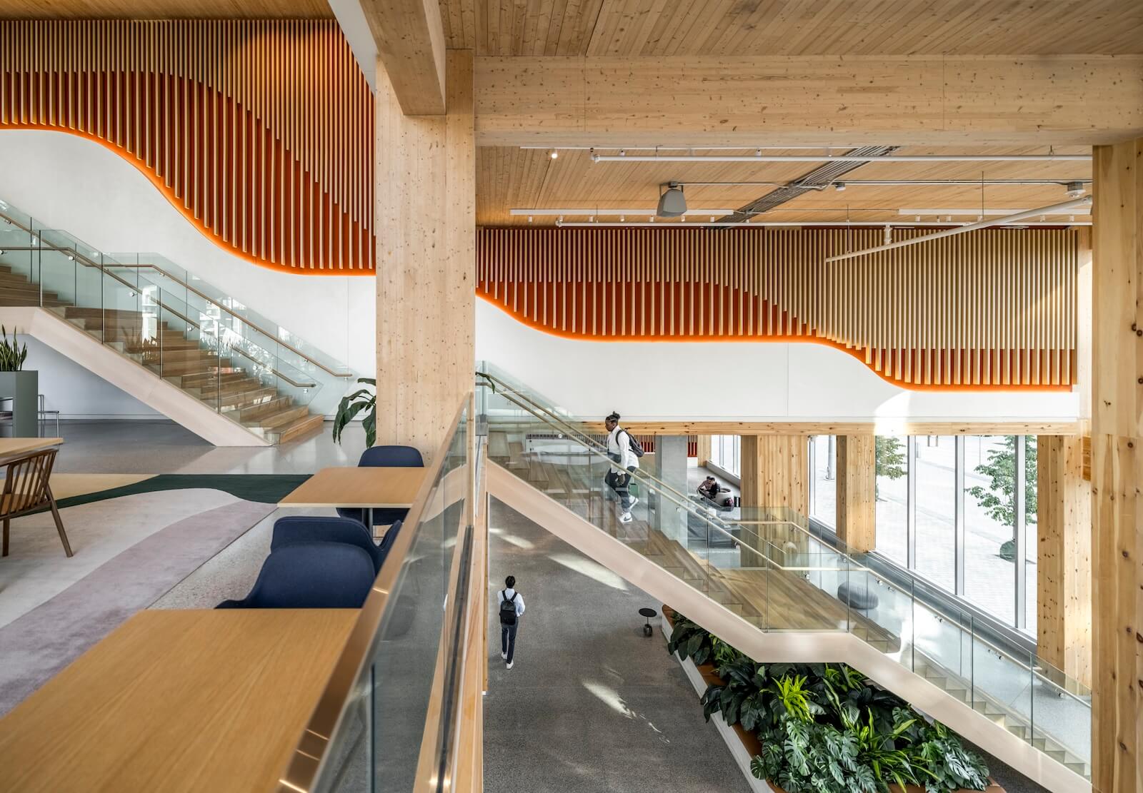 At East Bayfront Toronto, Waterfront Toronto’s offices are now located in the new T3 building (top of article), a tall mass timber structure with a zigzagging facade detail that makes the interior — including the double-height tenant lounge (here and below) — fully visible.