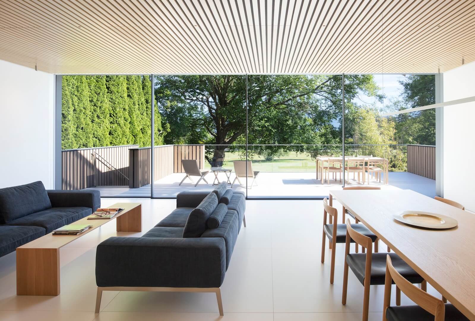 The interiors throughout feature porcelain tile flooring from Dekton by Cosentino and acoustic ceilings crafted with quarter-sawn white oak–veneered slats.