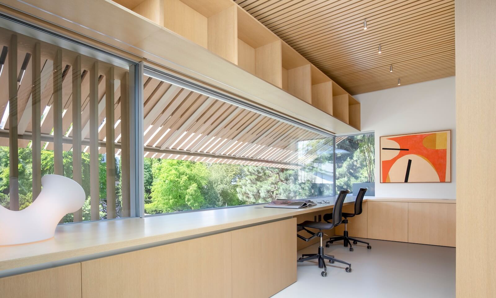 In the second-floor study, the origami-like facade’s screens of Alaskan yellow cedar strategically filter the street-side view.