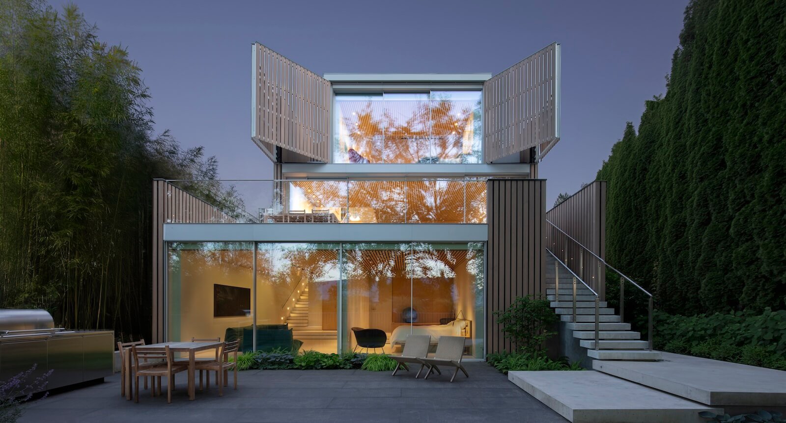 A tiered elevation comes into full view at the back of the house, where operable shutters slide away on a track to provide the primary bedroom with a majestic vista.