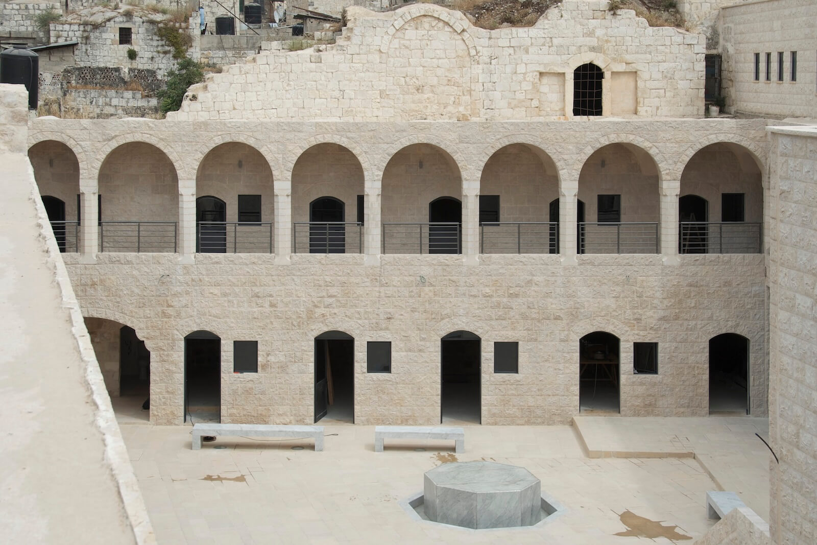 The Khan al- Wakalah was built in the early 17th century out of local Nablus stone. After its restoration, Elias Khuri and Davide Pagliarini were brought on to design the courtyard, paving and new openings; they used readily available Carrara marble for the public furniture.