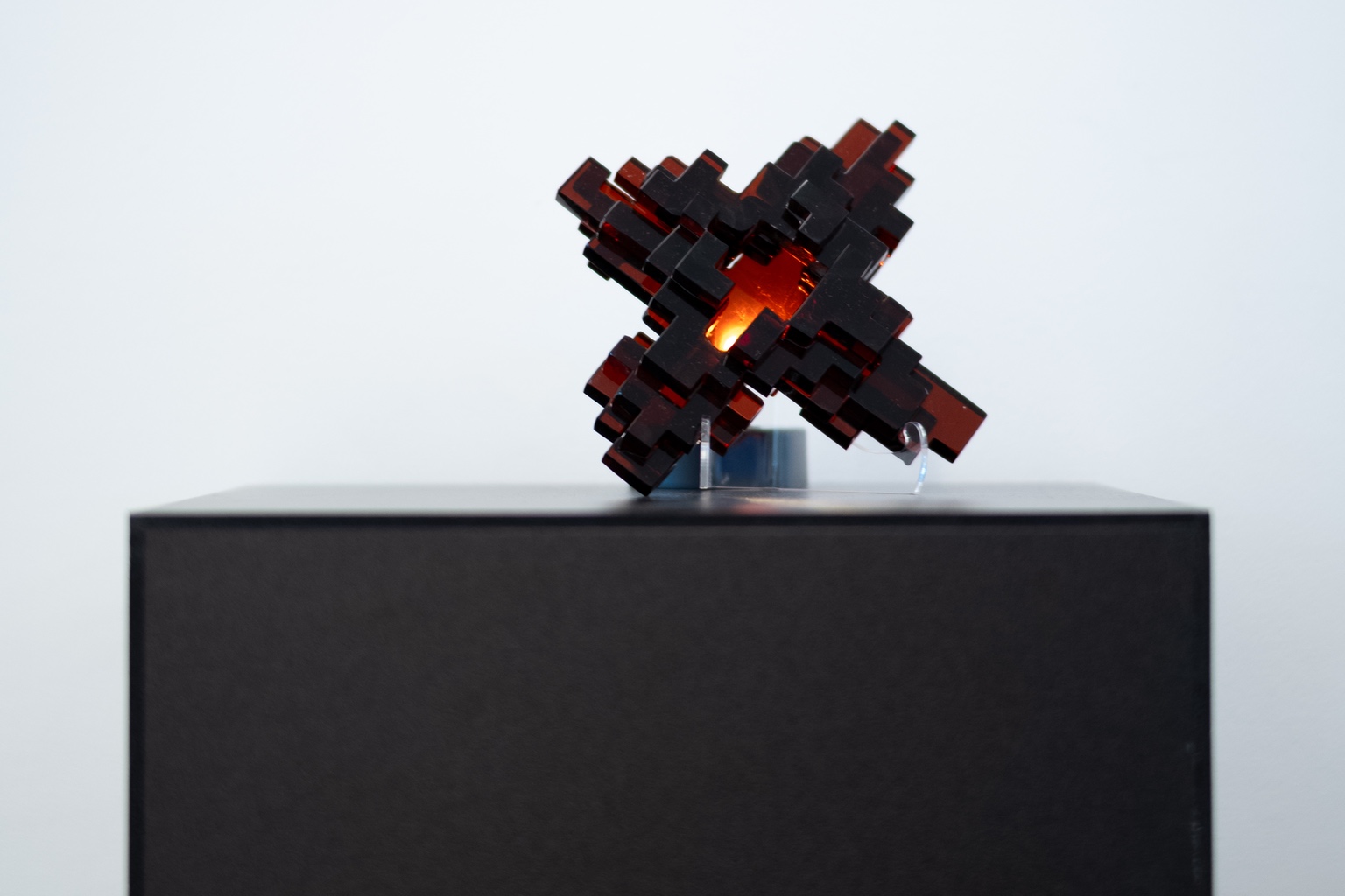 A glowing glass sculpture composed of many stacked cubes.