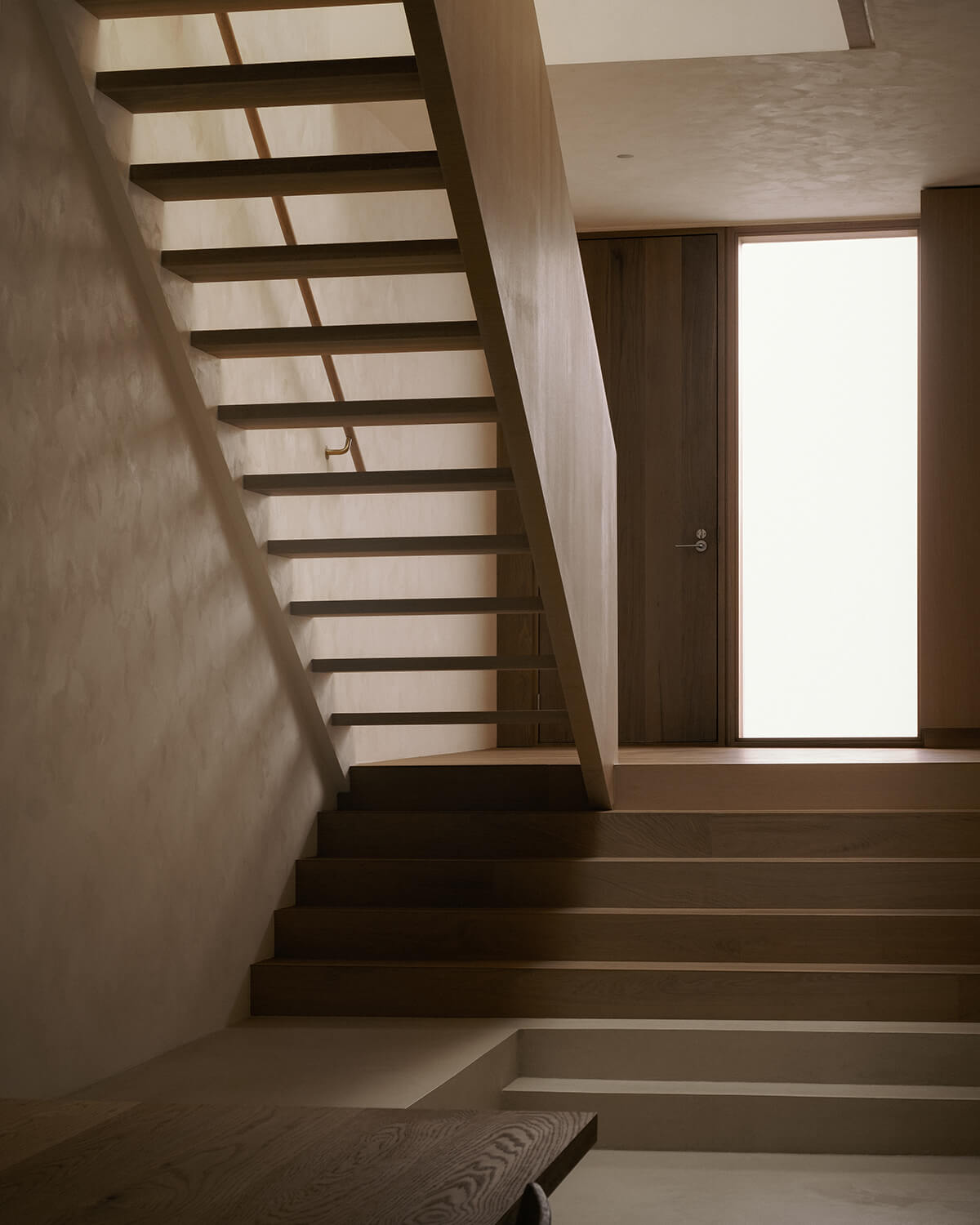 At the entrance to StudioAC's Junction Semi project, a staircase floats up to the second storey.
