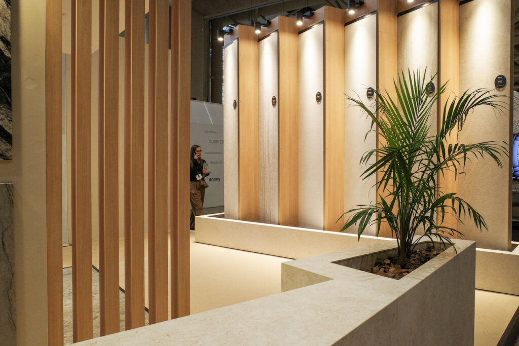 A wall of angled brown Dekton slabs and large fern in the Cosentino booth at IDS 2025.