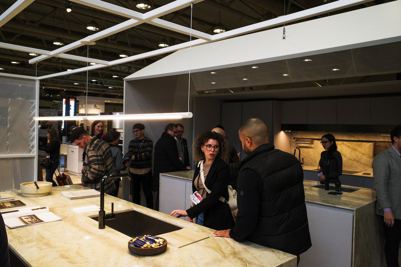 IDS 2025 visitors moving past the marble countertops of Fisher & Paykel, Arclinea and designer Guido Constantino Projects' Thea kitchen.