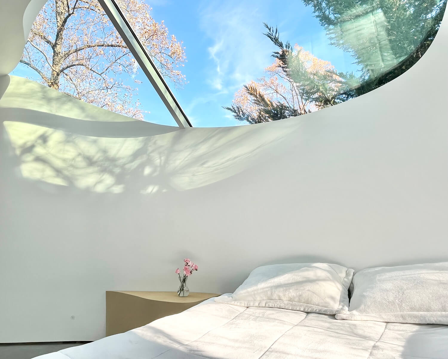 The effect of the addition peeling away from the old house — and revealing scoops of sky in the space between — achieves its highest sense of drama in the bedroom.