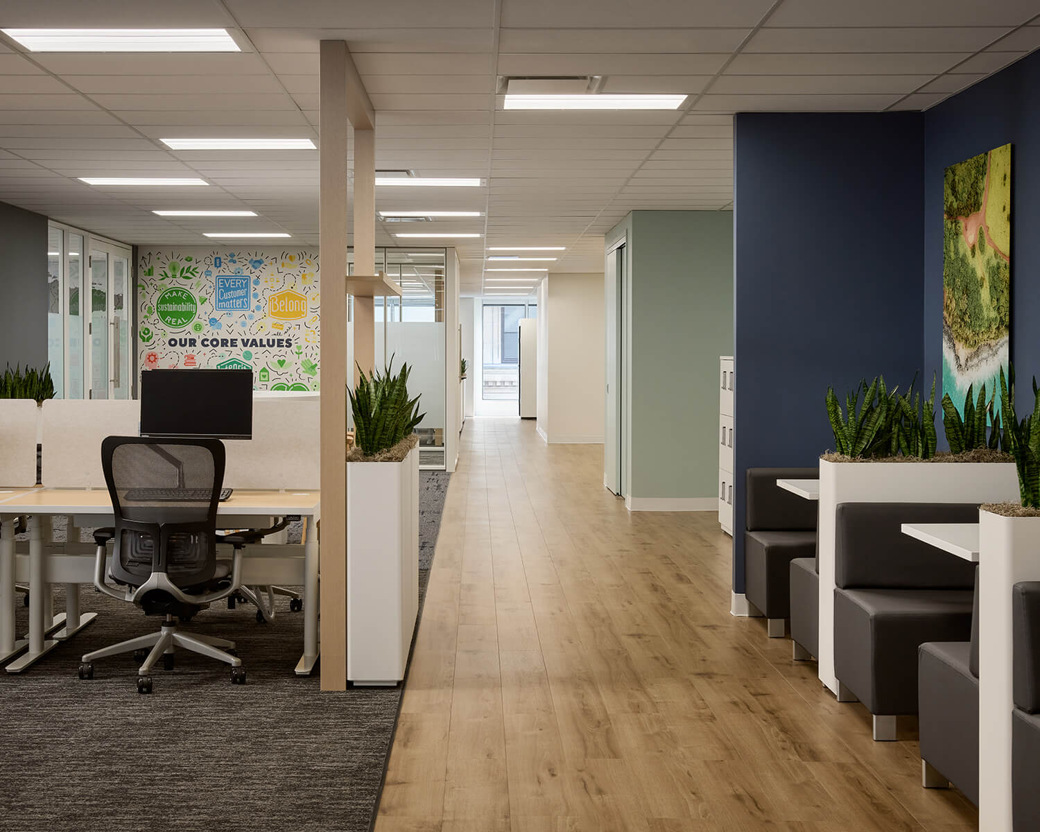 Custom planters at the end of the pre-owned workstations cleverly conceal power feeds that extend down from the ceiling, negating the need to core the floor.