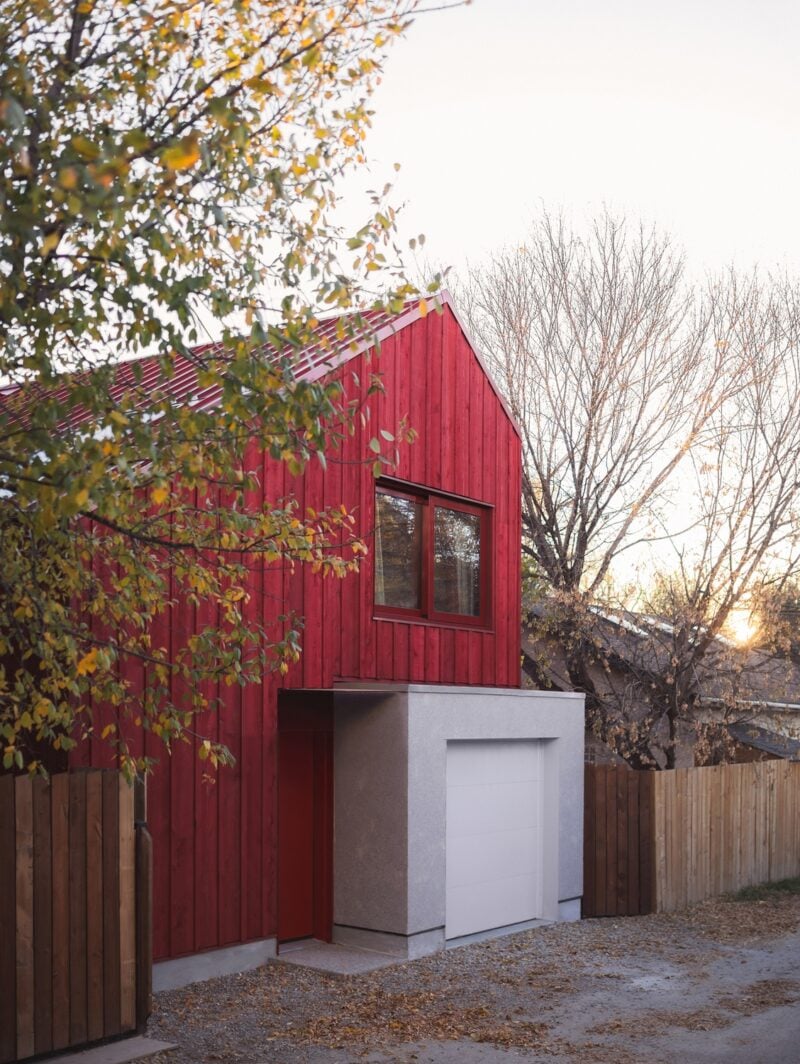 An angular Calgary laneway home by Bold Workshop Architecture featuring angular wood-framed construction with a rectangular concrete volume extending out from the base.